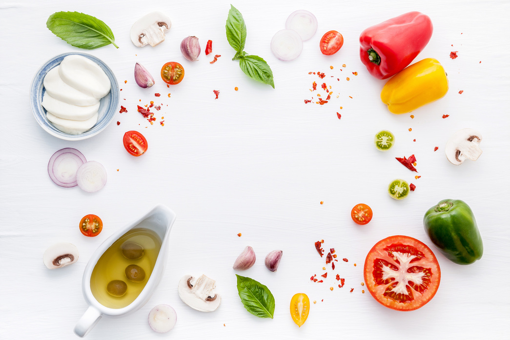 The ingredients for homemade pizza on white wooden background.